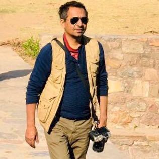 Anil carrying his camera outdoors